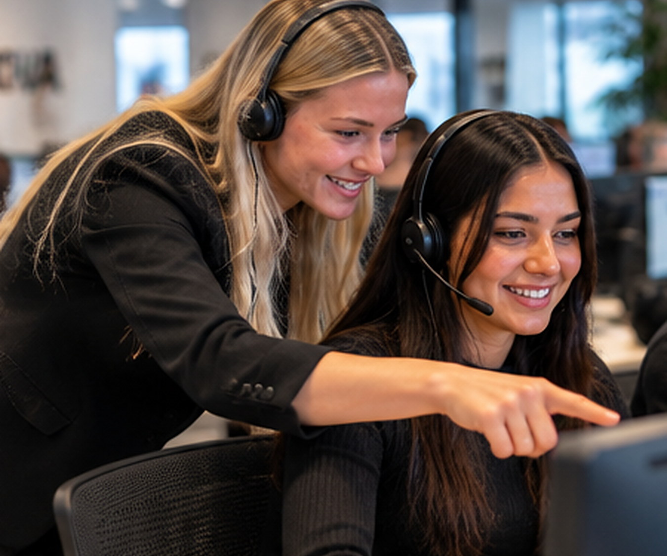 Twee collega's bekijken samen een aanbod op een computerscherm